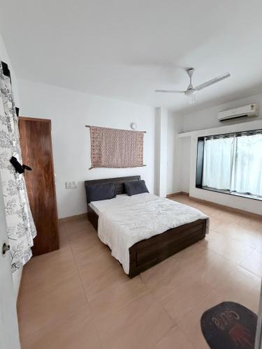 a bedroom with a large bed and a window at Hidden Hearts Cottage in Lonavala