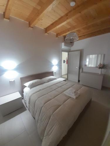a bedroom with a large bed with two lights at La Cilinella del Salento in Copertino