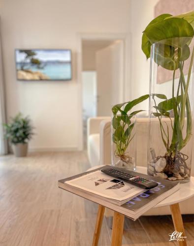 a table with a vase with a plant on it at La Maison Fois - Appartamento Quartucciu in Quartucciu
