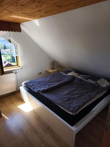a bed in a attic room with a bedvisor at Ferienhaus König in Kurort Steinbach-Hallenberg