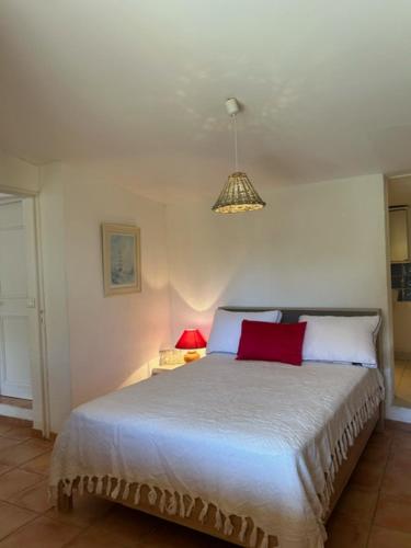 a bedroom with a large bed with two red pillows at villa des calanques in Conca