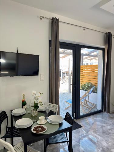 a dining room with a table and chairs and a television at Domki, Apartamenty U Adama i Ewy Morska Bryza Gąski, jacuzzi, sauna in Gąski