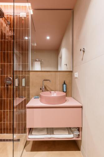 a bathroom with a pink sink and a shower at Nava Star Hotel in Durrës