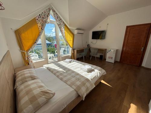 a bedroom with a bed and a large window at Laguna Boutique Hotel Bazaleti Lake in Dushetʼi