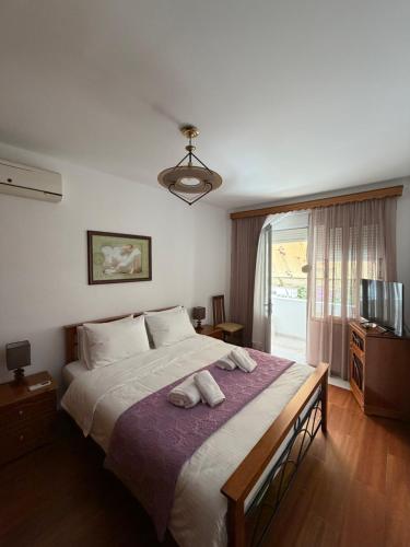 a bedroom with a bed with two towels on it at Alex Guest Apartment in Gjirokastër