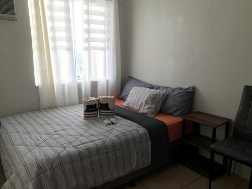 a bedroom with a bed with two shoes on it at MJ Luxury Living in Iloilo City