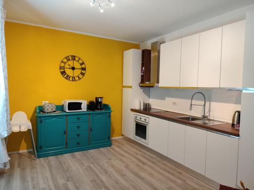 a kitchen with a blue cabinet and a clock on the wall at Casa LUIS in Luino