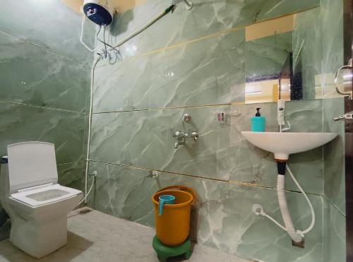 a bathroom with a toilet and a sink at Hotel Shree Raghunandan Palace in Ujjain
