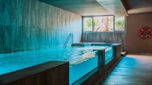 a large swimming pool with blue water in a room at Hotel Tarifa Lances, a member of Radisson Individuals in Tarifa
