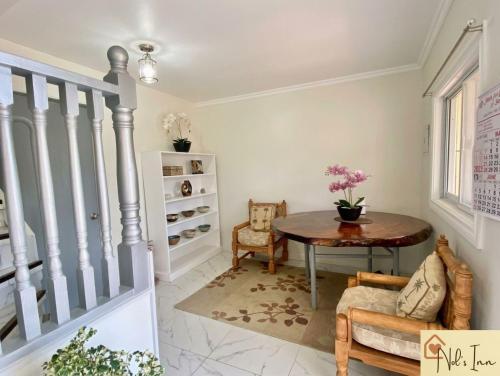 a living room with a table and a staircase at Nol's Inn in Iloilo City
