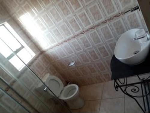 a bathroom with a toilet and a sink at The Seige Guesthouse in Pretoria