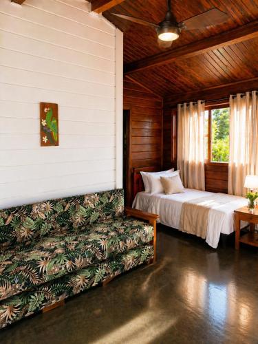 a bedroom with a bed and a couch in a room at Sopro do Vento Roots Hotel in Analândia