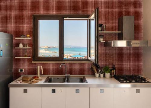 a kitchen with a sink and a view of the ocean at Terrazza Sul Mare in Trapani