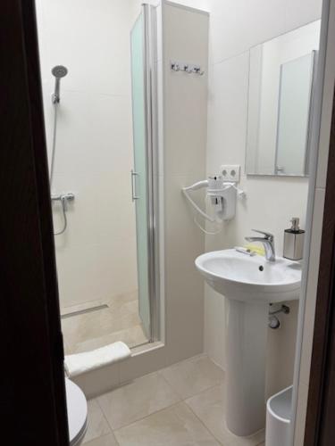 a white bathroom with a sink and a shower at Готель-ресторан Октан in Holovanivs'k