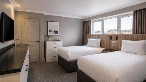 a hotel room with two beds and a flat screen tv at Coachmans Rest in Sandwich