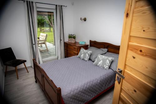 a bedroom with a bed and a sliding glass door at Domki letniskowe Malina 1 in Gawrony