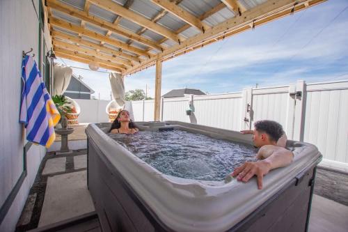 a man and woman in a hot tub on a patio at The Frida Tiny House-Hot Tub-Pet Friendly-No Pet Fee! in Albuquerque