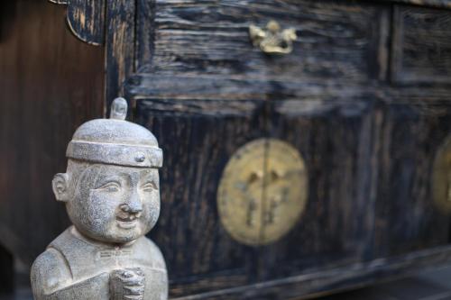 a statue in front of a wooden chest at The Great Wall Courtyard Hostel in Yanqing