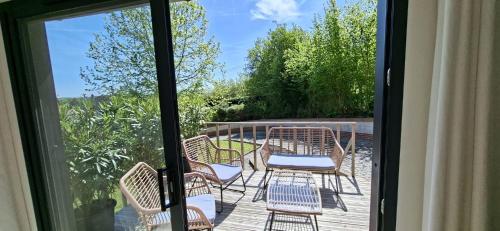 a patio with chairs and tables on a deck at Cabane Cozy & Calme in Janville