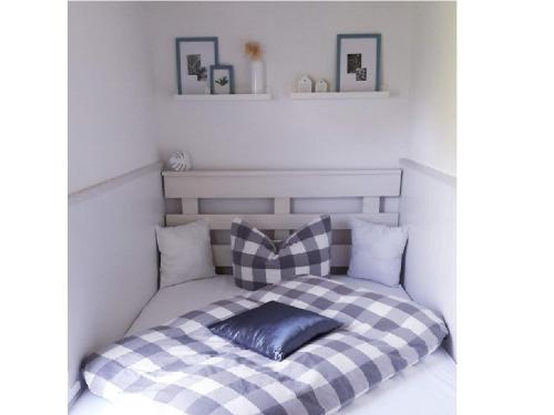 a bed with a black and white checkered blanket at Ferienhaus Abendrot in Basedow