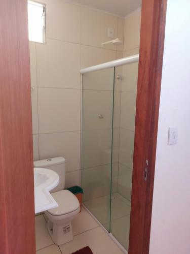 a bathroom with a toilet and a glass shower at Angelsuites in Maceió