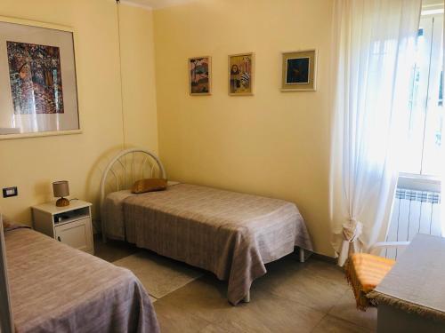a bedroom with two beds and a window at Casa Roberta a Lucca in Lucca