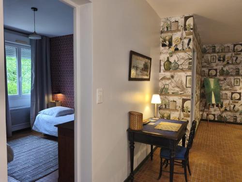 a room with a desk and a bedroom with a bed at Aubrion de Cremens in Magnan