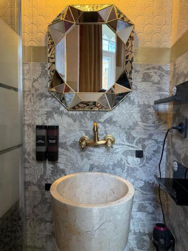 a bathroom with a large sink and a mirror at La Maison de Traverse in Vichy