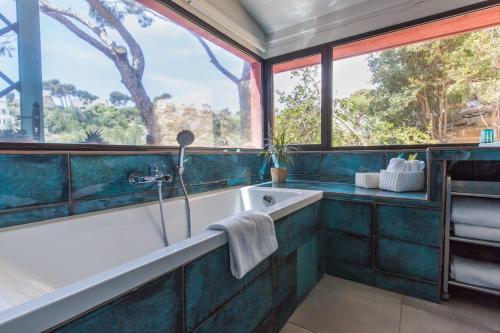 a bathroom with a tub and a large window at Le Jardin d'Emile in Cassis