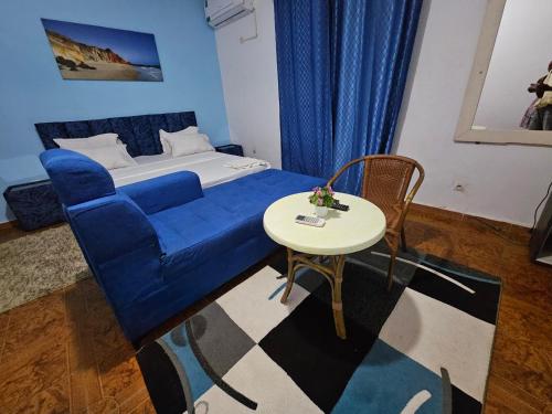 a bedroom with a blue couch and a table at Vince Saly in Saly Portudal