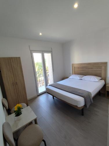 ein Schlafzimmer mit einem Bett, einem Tisch und Stühlen in der Unterkunft Nbm in Puerto de Gandía