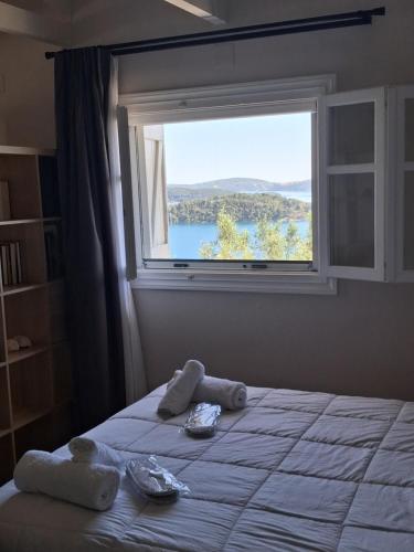 a bedroom with a bed with a large window at Blue Horizon Rock-Sea View Apartment in Nidri in Nydri