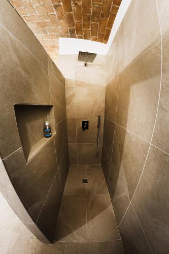 un bagno con doccia con piastrelle marroni di Murorotto a Castello del Matese