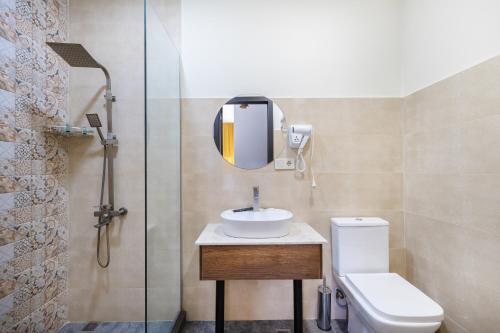 ein Badezimmer mit Waschbecken, Toilette und Spiegel in der Unterkunft Melodia KAZBEGI in Kazbegi