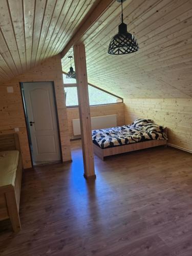 a bedroom with a bed in a wooden room at Casa Tudor - Râul Mare Retezat in Clopotiva