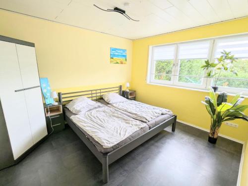 a bedroom with a bed in a room with yellow walls at Ferienwohnung Eifeltraum in Masburg