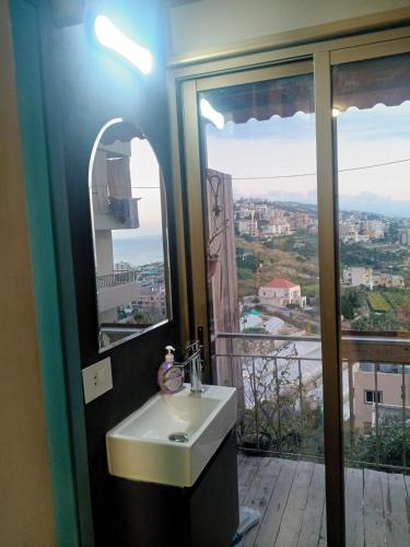 a bathroom with a sink and a view of a city at Z House Jbeil in Jbeil