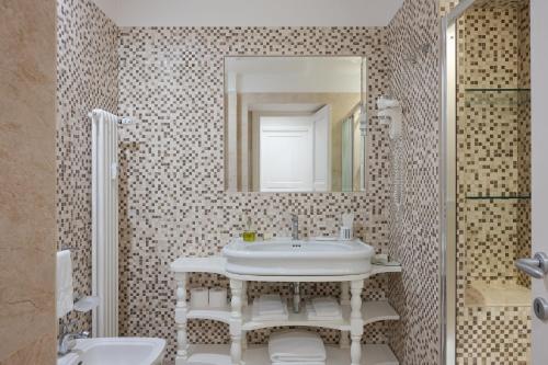 a bathroom with a sink and a mirror at Altarocca Embassy Rome in Rome