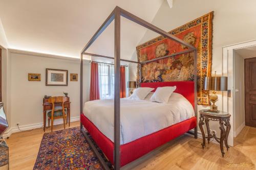 a bedroom with a canopy bed and a rug at Manoir Des Douets Fleuris in Cancale