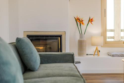 a living room with a couch and a fireplace at Villa Enalia Paphos in Paphos