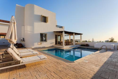 a villa with a swimming pool and a house at Villa Enalia Paphos in Paphos