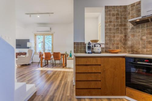 a kitchen with wooden cabinets and a dining room at Villa Enalia Paphos in Paphos
