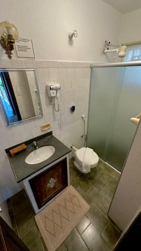 a bathroom with a sink and a toilet and a shower at Pousada das Artes in Tiradentes