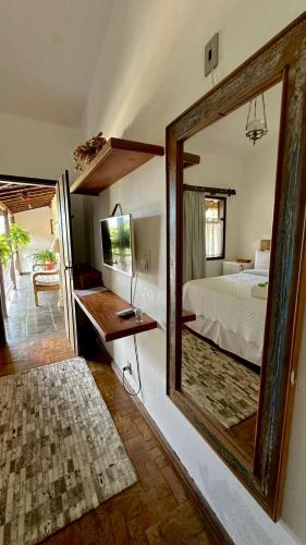a mirror in a room with a bed and a bedroom at Pousada das Artes in Tiradentes
