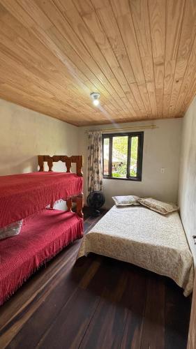 a bedroom with two beds and a wooden ceiling at Sítio Rio Lima in Rio Forcação