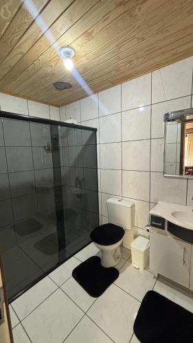 a bathroom with a shower and a toilet and a sink at Sítio Rio Lima in Rio Forcação