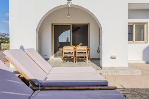 a patio with an archway with a table and chairs at Nireas Villa in Paphos