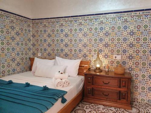 a bedroom with a bed and a dresser with towels at Surf Riad Taghazout in Taghazout