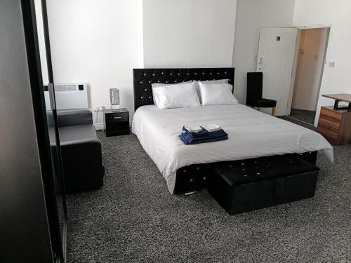 a bedroom with a large bed and a chair at Liv's place in Oldbury