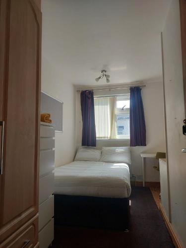 a small bedroom with a bed and a window at Peace House in Leeds